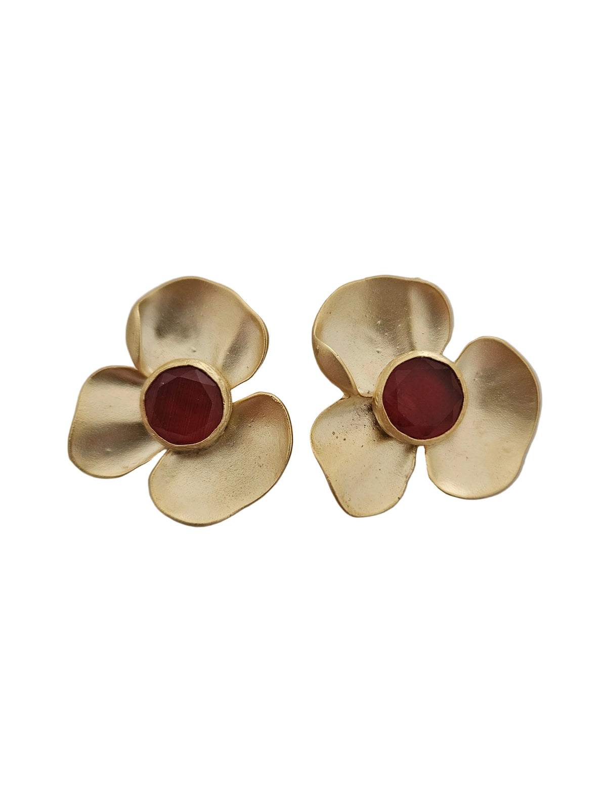 A pair of gold flower-shaped earrings with round dark red orange gemstone centers